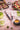 Fotografía de tenedor y cuchillo chuletero serie The Origin tono azul rodeada de platos de comida y bebida